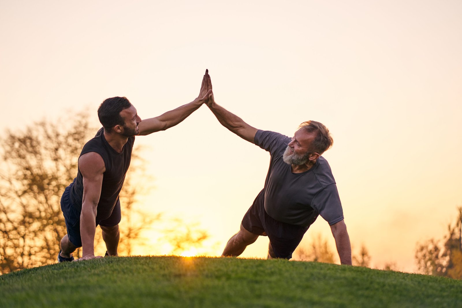 The two sportsmen push up together on the sunset background